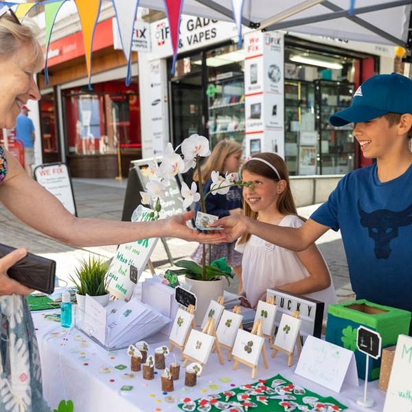 A boy and girl completing a sale at their plant stand