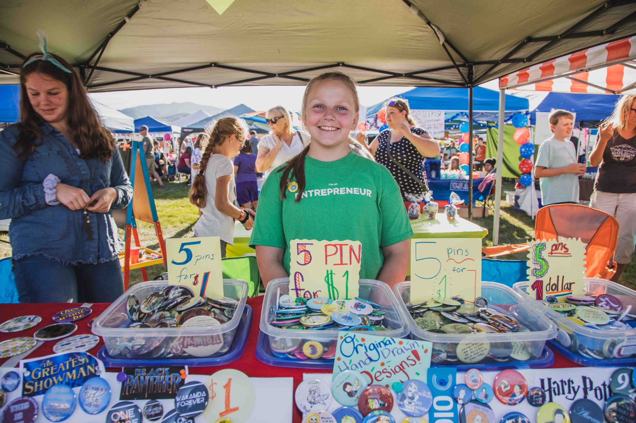 Young founder running a pin business at a market