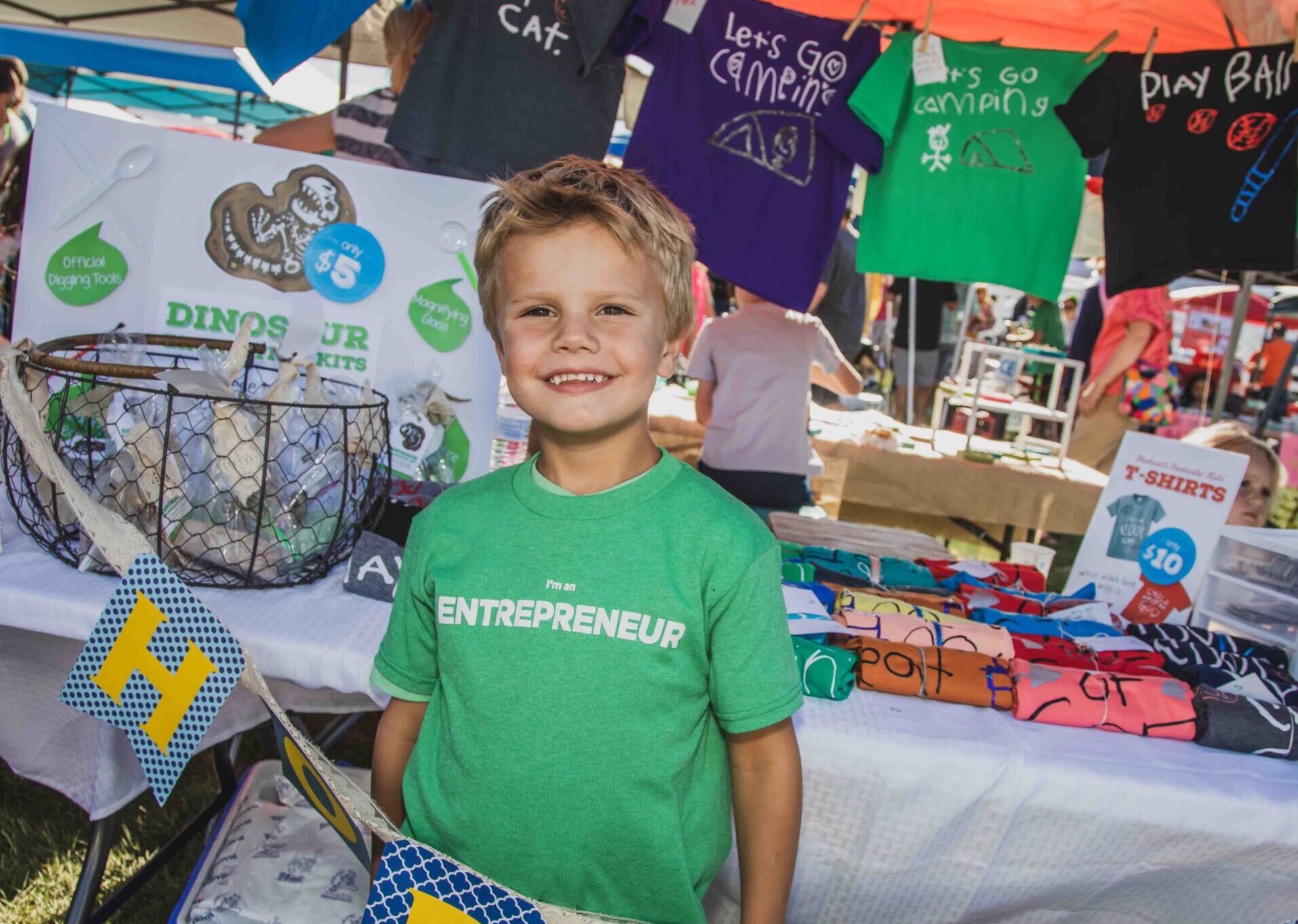 A young boy running his T-shirt and dinosaur business